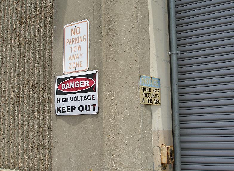 three signs on an electrical substation
